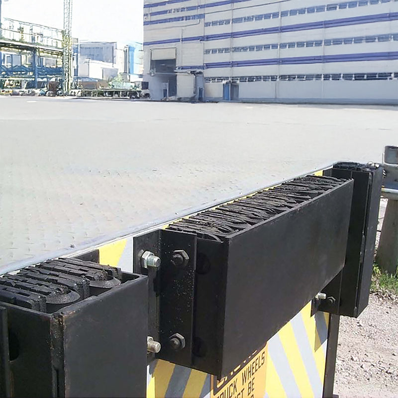 Black metal platform on a concrete surface, industrial building in the background.