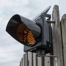 Amber solar powered 8 inch traffic light mounted outdoors.