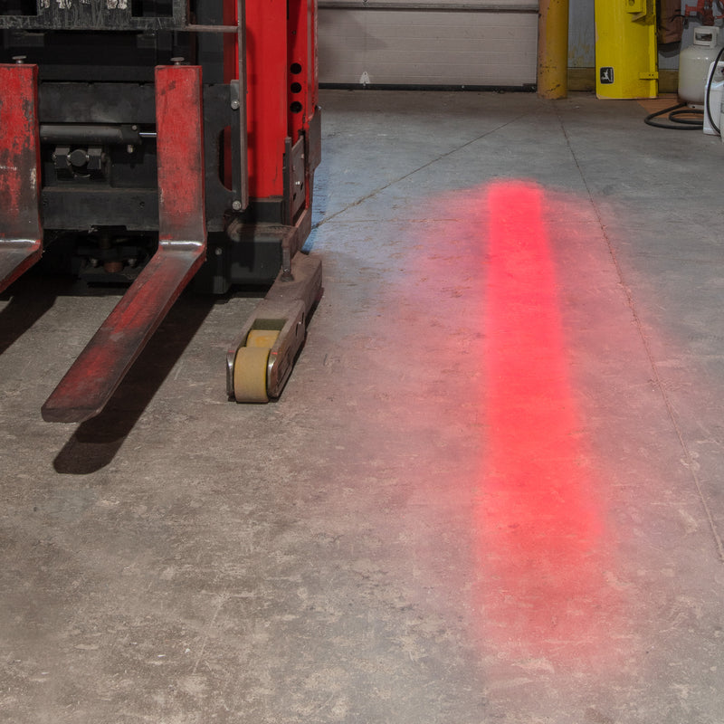 Redline illuminated on concrete floor by a forklift